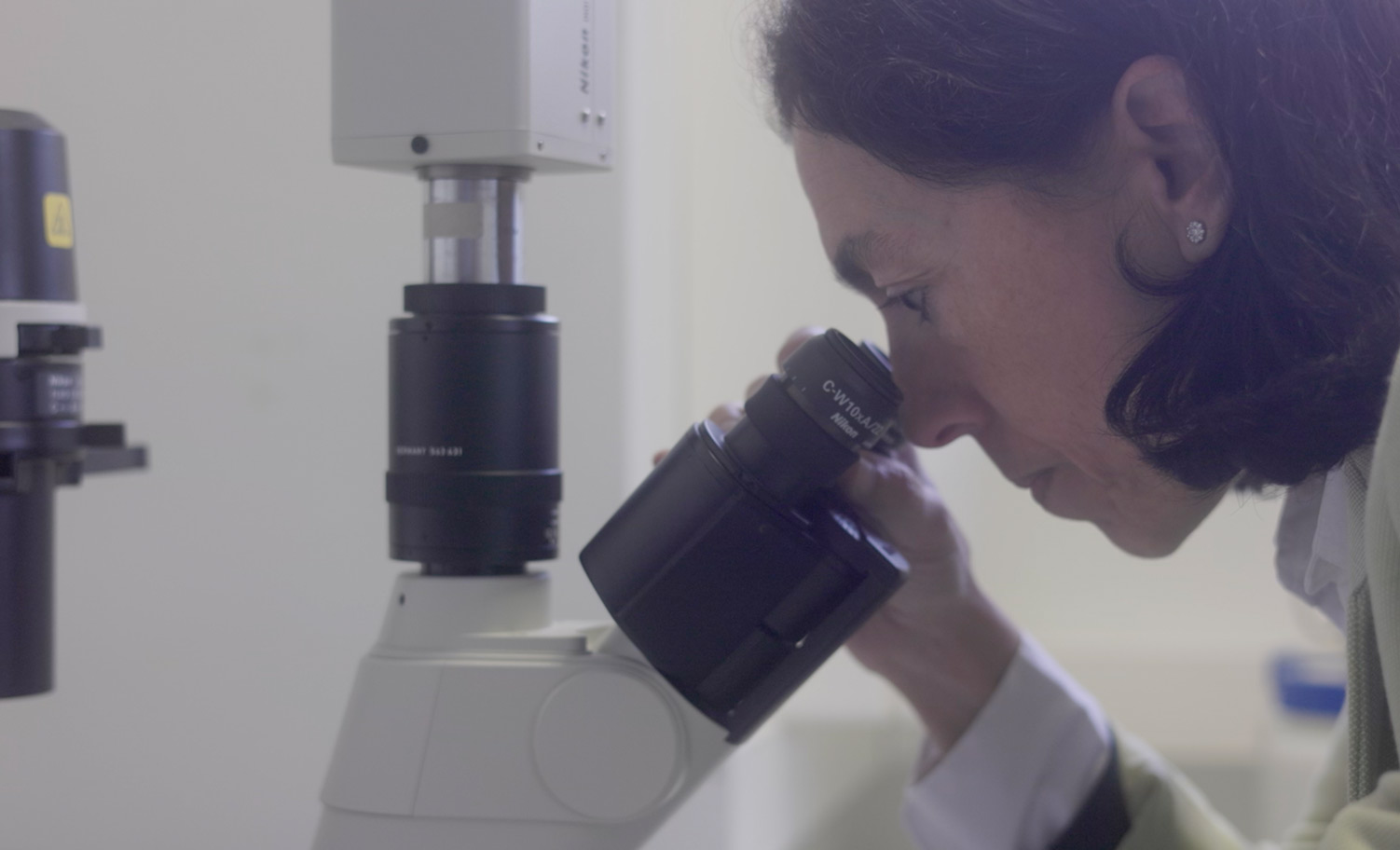 Doctora mirando por un microscopio