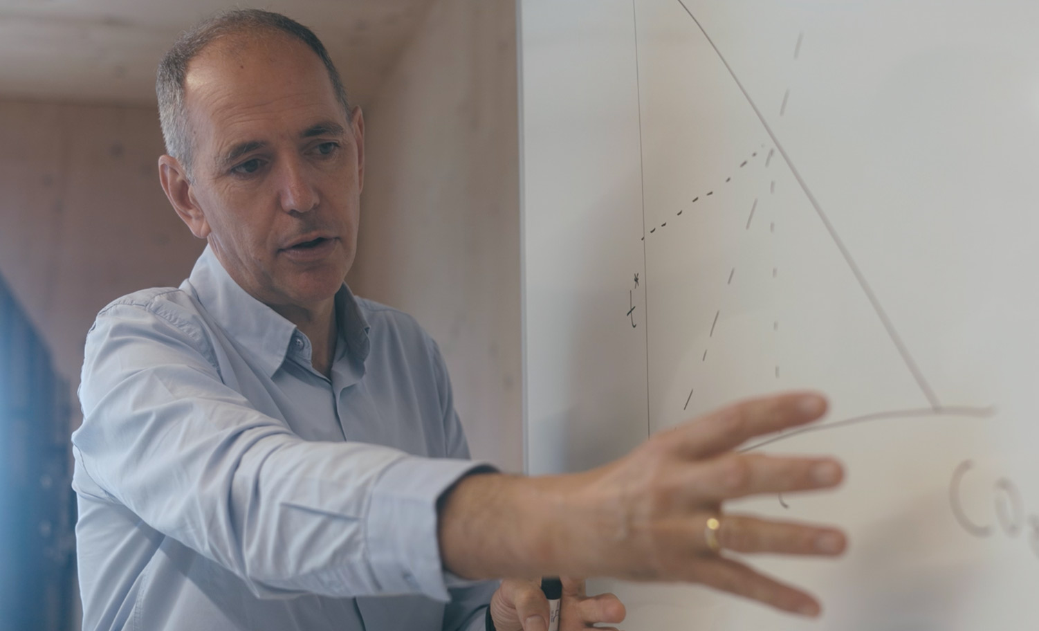Retrato del doctor dando clases en una pizarra señalando con la mano